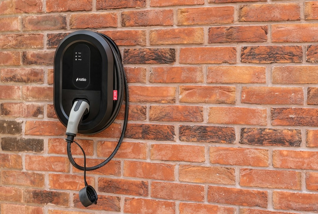 Electric vehicle charging station mounted on a red brick wall.