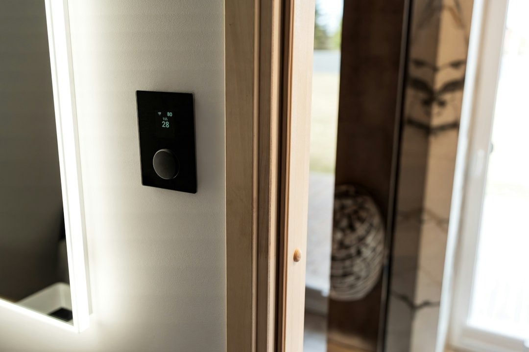 Smart home control panel on grey wall with temperature display.
